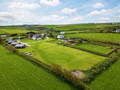A rural landscape with green fields several houses and farm buildings at Campion Lodge in Port Isaac