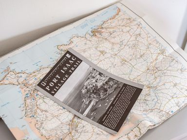 A printed map with a Port Isaac Village Trail guide on top at Puffin Lodge in Port Isaac