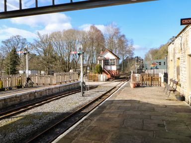 A train station platform with railway tracks signal posts and a small signal box at Cross View Cottage in Alston