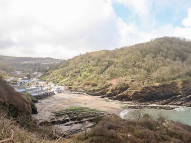 A coastal village with houses and a sandy beach surrounded by hills at Beach Road House in Hele Bay Ilfracombe
