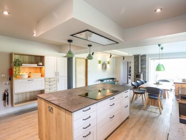 A kitchen with an island and dining table with chairs at Rynys in Llanddeiniolen near Llanrug