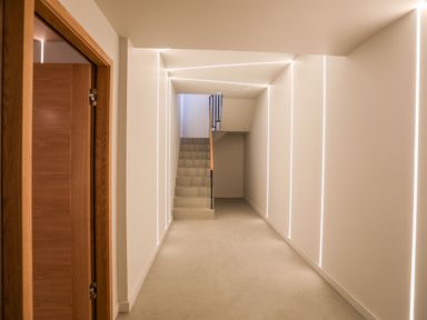 A hallway with stairs and wooden doors at Rynys in Llanddeiniolen near Llanrug