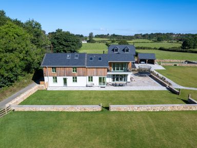 A house with a garden, patio, trampoline, and carport in a rural area at Rynys in Llanddeiniolen near Llanrug