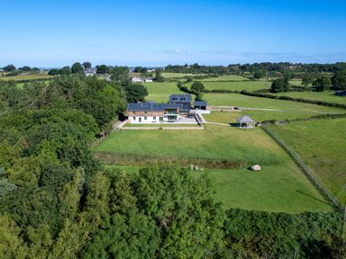 A rural property with a house a lawn a gazebo and surrounding fields at Rynys in Llanddeiniolen near Llanrug