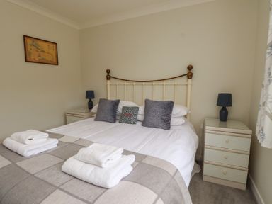 A bedroom with a bed and bedside tables at Bro Mebyd in Criccieth