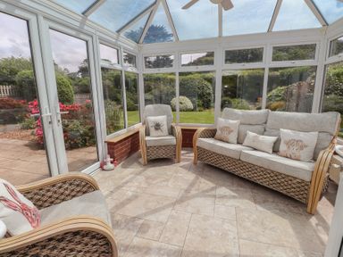 A conservatory with seating area at Bro Mebyd in Criccieth