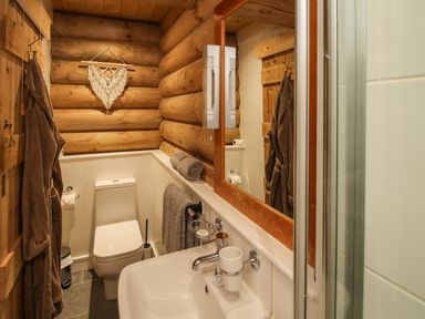A bathroom with a toilet sink mirror towel and bathrobe at Brynallt Country Park Frankton near Ellesmere