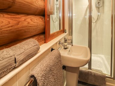 A bathroom with a sink mirror towels and a shower at Brynallt Country Park Frankton near Ellesmere