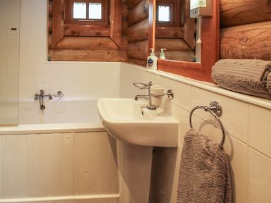 A bathroom with a bathtub sink mirror soap dispenser and towels at Brynallt Country Park Frankton near Ellesmere