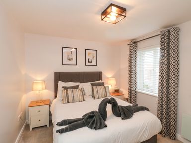 A bedroom with a double bed and bedside tables with lamps at Estuary Walk in Whitby