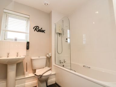 A bathroom with a sink toilet bathtub shower and window at Estuary Walk in Whitby