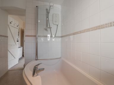 A bathroom with a bathtub and a shower at Hillcrest in Oxwich near Port Eynon