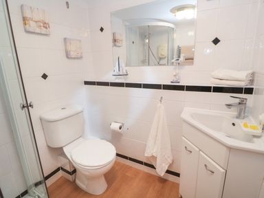 A bathroom with a toilet sink shower and towel at 58 High Street in Falmouth