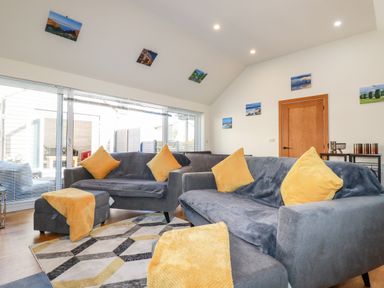 A living room with grey sofas yellow cushions and a geometric rug at Clonmore in Bodmin