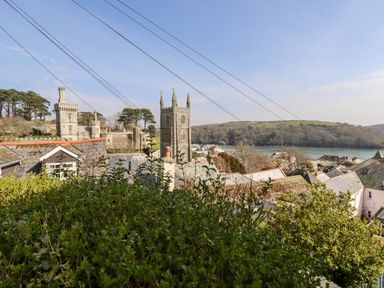 View over rooftops with church towers and water in the background at Driftwood in Fowey