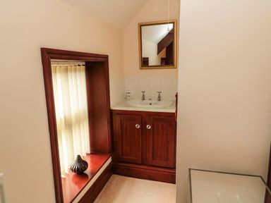 A small bathroom with a sink cabinet mirror and a window with blinds at The Granary in Longhirst near Morpeth