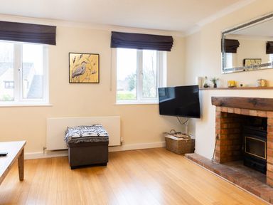 A living room with a fireplace and television at White Stones in Fulbrook, near Burford