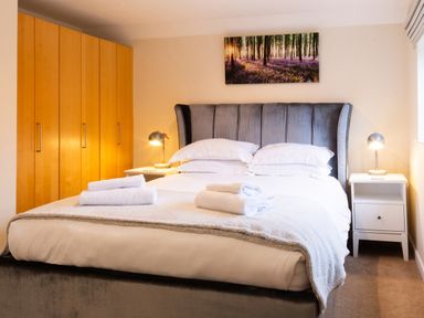 A bedroom with a bed and wardrobe at White Stones Fulbrook, near Burford