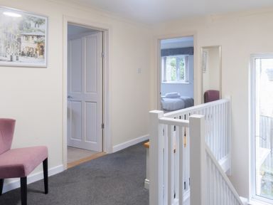 A hallway with a chair and doors at White Stones, Fulbrook, near Burford