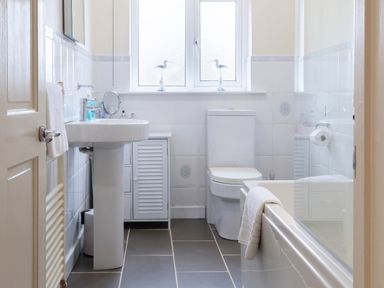 A bathroom with bathtub, sink, and toilet at White Stones Fulbrook, near Burford