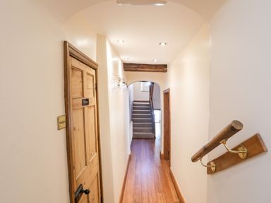 A hallway with wooden floor a wooden door labeled private handrail on the right wall and stairs at the end at Above Deck in Beaumaris