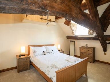 A bedroom with wooden bed frame bedside tables and a chest of drawers at Above Deck in Beaumaris