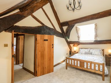 A bedroom with a wooden bed and two bedside tables with lamps at Above Deck in Beaumaris