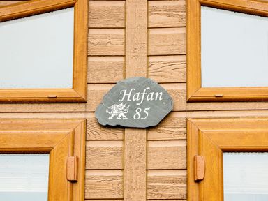 A wooden wall with a stone plaque reading Hafan 85 at Hafan Lodge 85 Wisemans Bridge near Saundersfoot