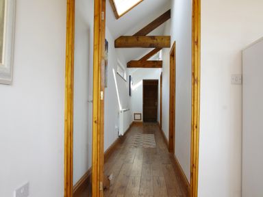 A hallway with wooden floor beams and a small rug at Haimwood Byetake in Llandrinio