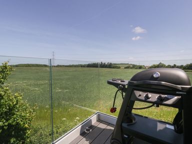 A balcony with a barbecue grill overlooking a green field at Little Knaplock in Fiddington near Combwich Somerset