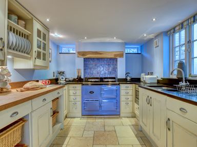 A kitchen with a blue oven and wooden countertops at Crab Cottage in Sandsend