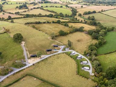 A view of fields and cabins in an outdoor setting at Oak Tree View Nantmel near Rhayader