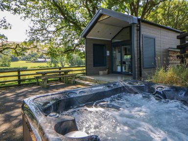 A hot tub with a bench and table at Oak Tree View Nantmel near Rhayader