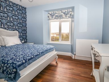 A bedroom with a bed a desk and a window with a view at Estcote Roger Ground near Hawkshead