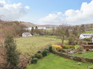 A rural landscape with grass fields trees houses and a garden at Estcote in Roger Ground near Hawkshead
