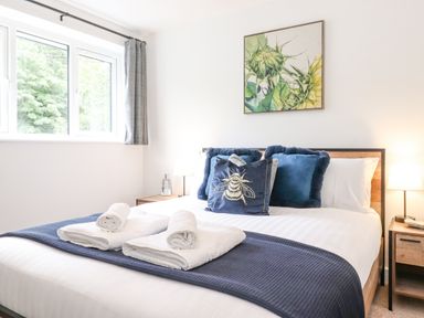 A bedroom with a bed made with blue and white bedding and towels on it at Rydal Rock in Ambleside