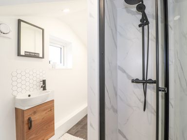 A bathroom with a shower and a sink with a mirror above at Rydal Rock in Ambleside