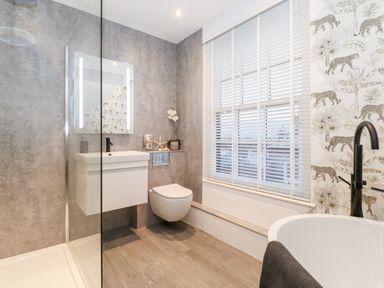 A bathroom with a walk-in shower sink toilet window with blinds and a bathtub at Fenty's in Bowness-On-Windermere