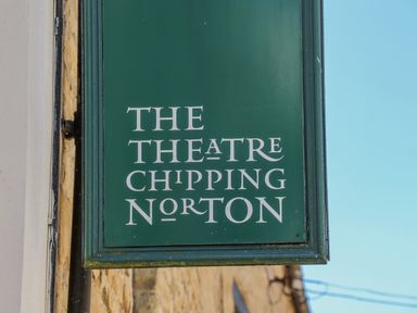 A green sign with white text reading The Theatre Chipping Norton on a building exterior