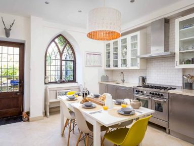 A kitchen with a white table set for breakfast and stainless steel appliances at Little Culver in Minchinhampton