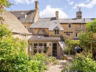 A stone cottage with a garden in front and a barbecue grill at Stanley Cottage in Chipping Campden