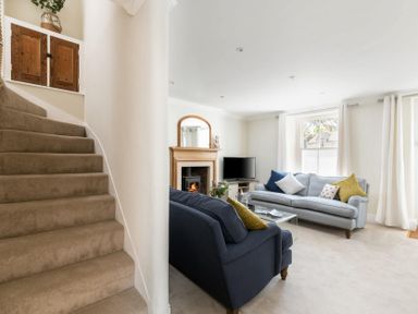 A living room with two sofas and a staircase nearby at Copperbeech in Stow-on-the-Wold