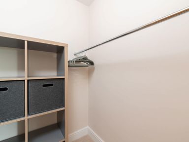 A closet with a wooden cubical shelving unit and empty hangers on a metal rod at Mount View in Childswickham