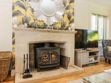 A living room with a fireplace and television at Bell Garden in Stow-On-The-Wold