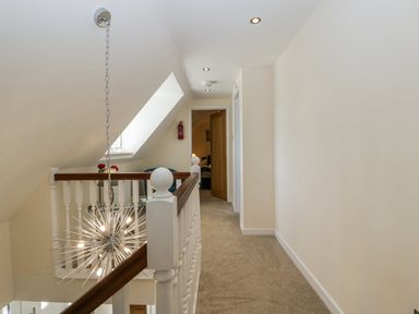 A hallway with a light fixture and carpet at Bell Garden in Stow-On-The-Wold