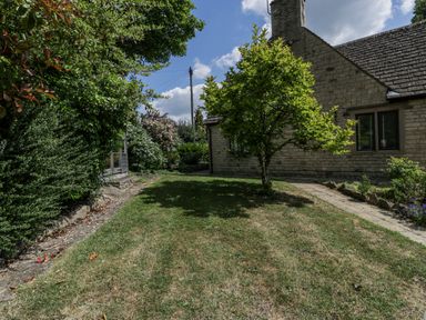 A garden with a house, tree and bushes at Bell Garden in Stow-On-The-Wold