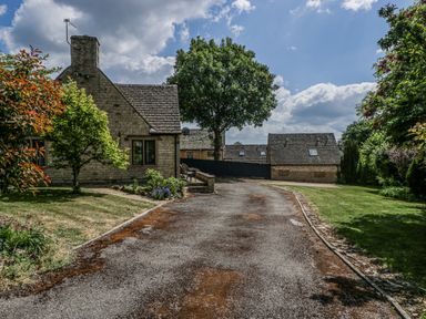 A house with a driveway and trees at Bell Garden in Stow-On-The-Wold