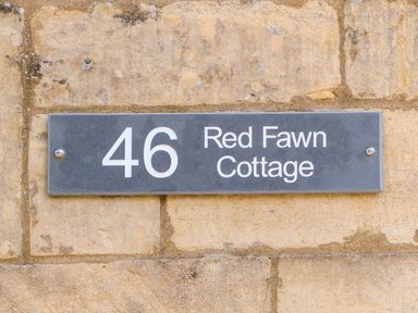 A house number sign with 46 Red Fawn Cottage on a stone wall at Red Fawn Cottage in Blockley