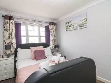 A bedroom with a bed and bedside tables with lamps at Beach View House in Wyke Regis