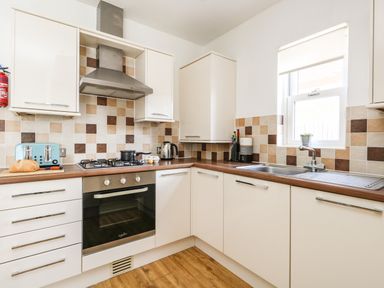A kitchen with a stovetop oven sink and cabinets at Marina Reach in Weymouth